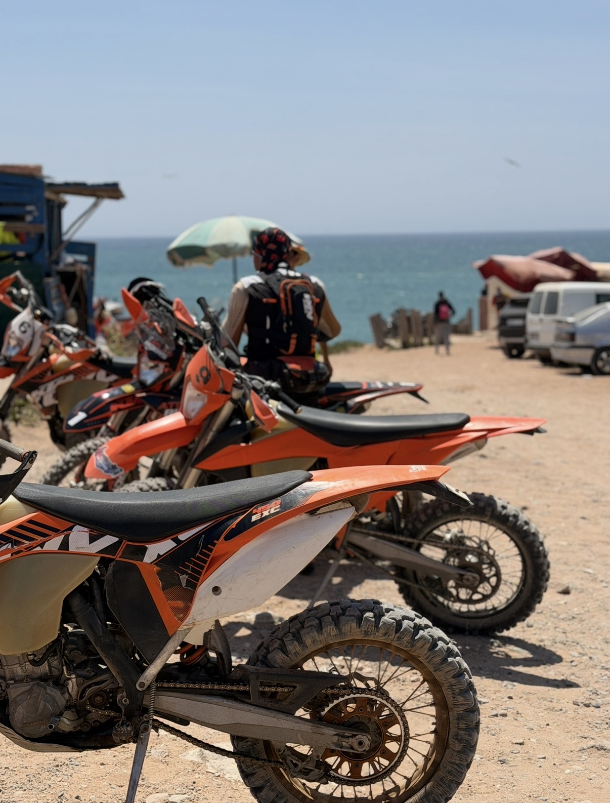 Motos KTM alignées face à l'océan — point de vue sur la côte d'Agadir