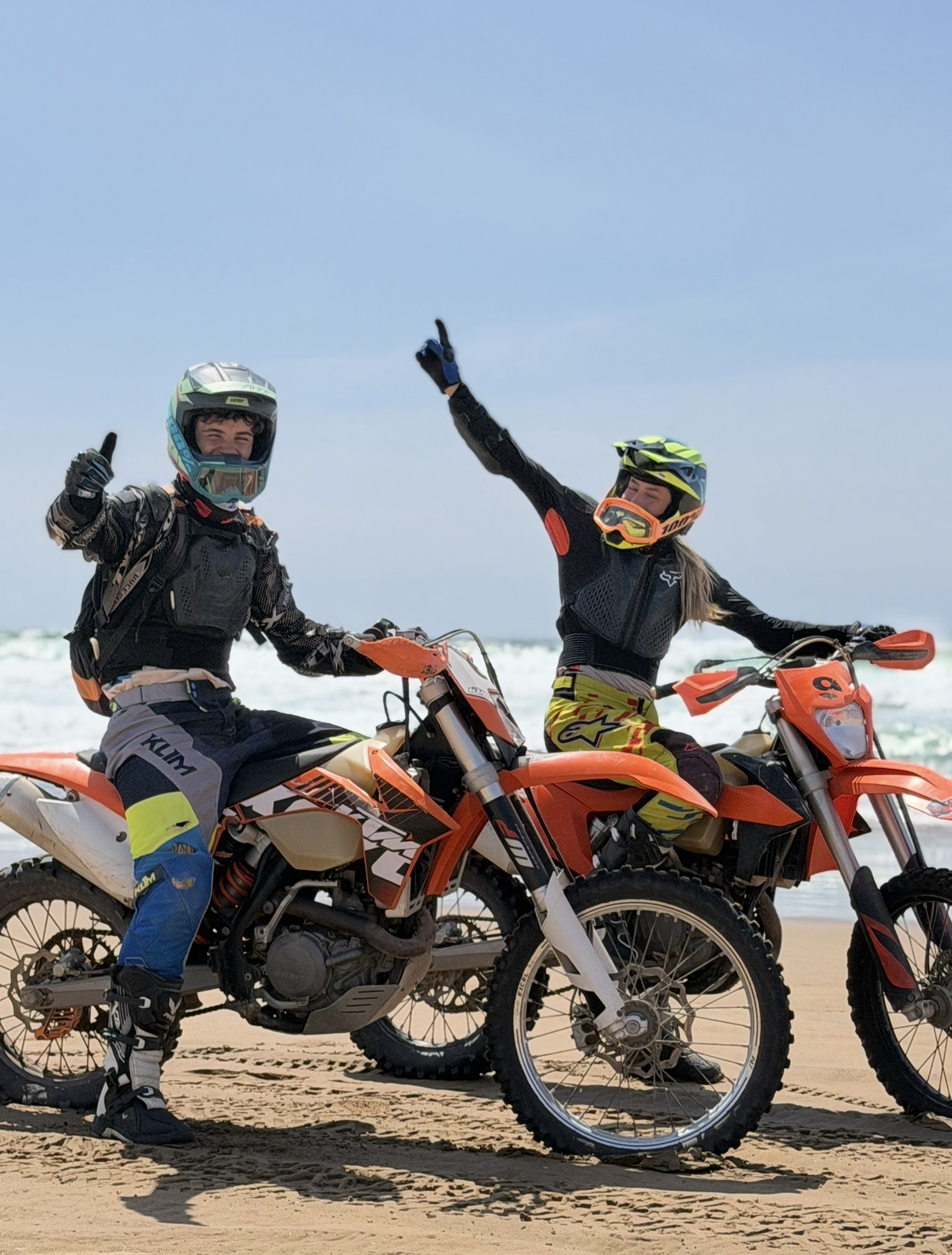 Pilotes enduro souriants en équipement complet sur la plage d'Agadir