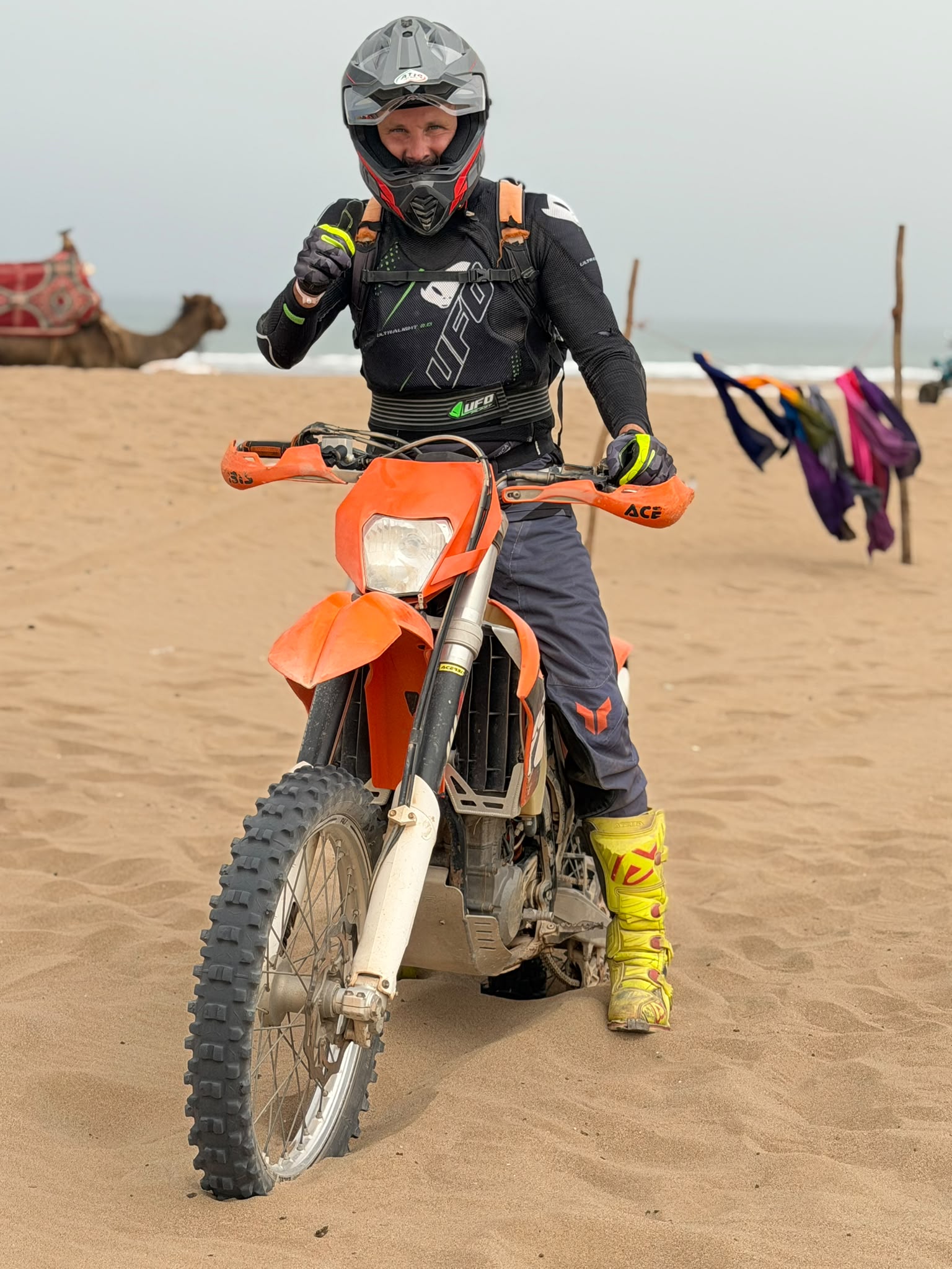 Pilote KTM 450 EXC-F en pleine action sur la plage sauvage d'Agadir, écume et sable dans les roues