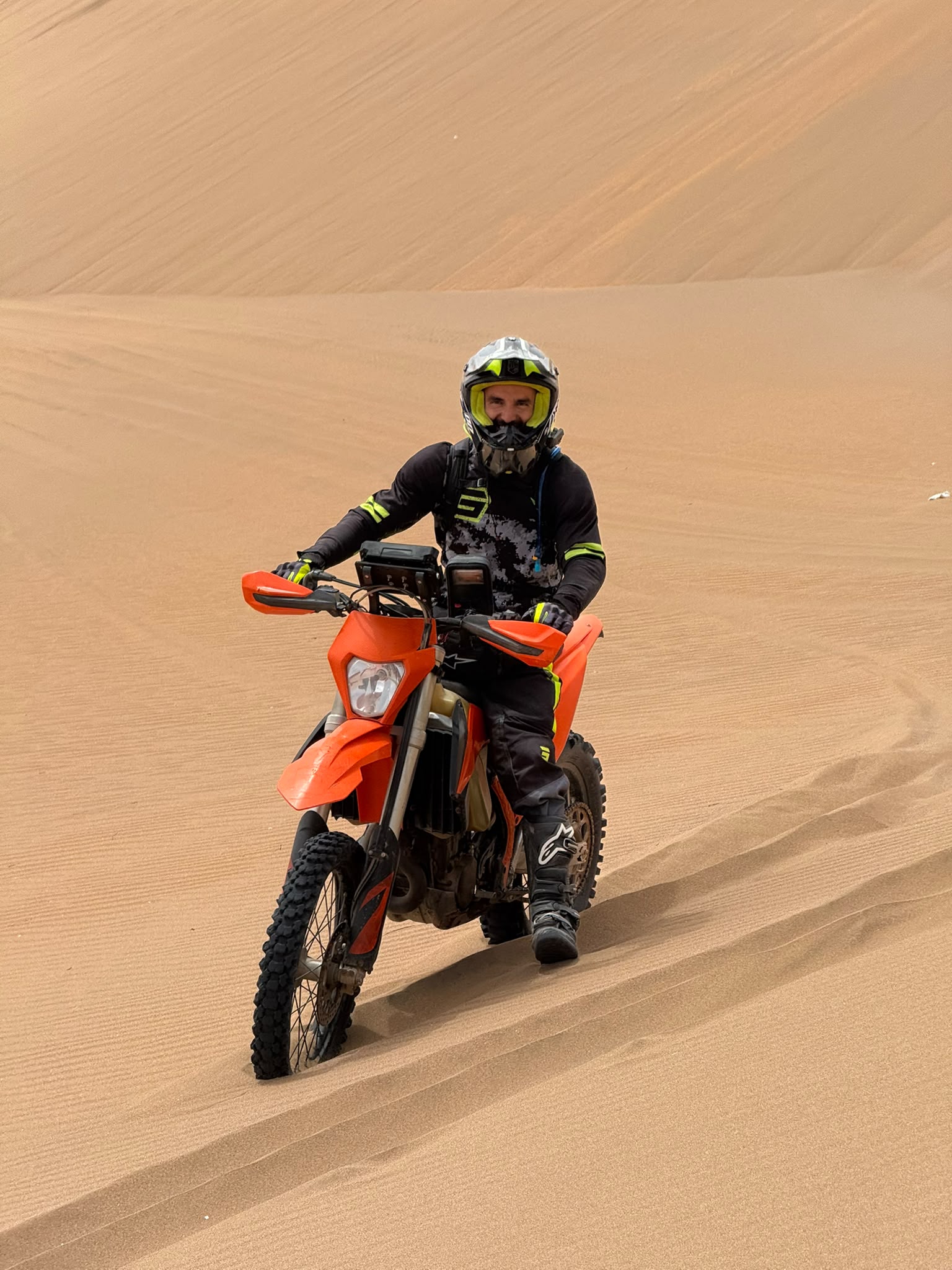 Sanoch au sommet d'une dune, KTM 450 EXC-F posée face au soleil couchant d'Agadir